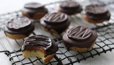 chocolate covered donuts sitting on a cooling rack