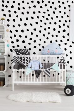 a white crib with black and white polka dot wallpaper