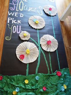 the paper flowers are placed on top of the blackboard