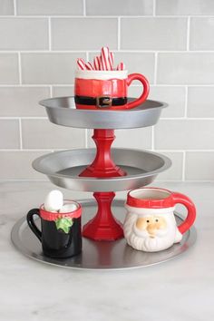 three tiered tray with coffee mugs and candy canes in santa's hat