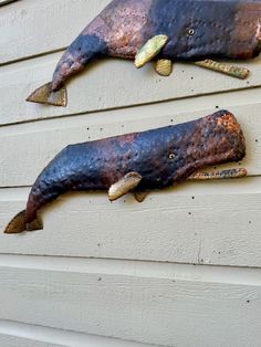 two metal animals on the side of a house