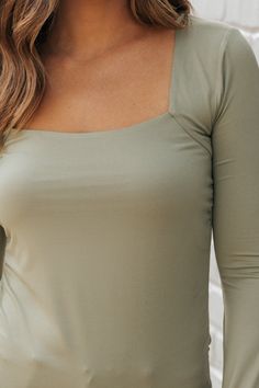 Expertly designed and crafted, our Ruched Jersey Square Neck Top is the perfect addition to your essentials list! Made with a luxurious polyester/spandex blend, this top features a square neck, long sleeves, and ruched sides for a flattering fit. Available in black, ecru, and green, it's a versatile and stylish choice for any occasion. Pairs perfectly with jeans, shorts, or trousers! Stretch Square Neck Tops In Elastane, Stretch Tops With Straight Neckline In Elastane, Fitted Long Sleeve Top With Scoop Neck, Spring Square Neck Tops With Elastane, Fitted Long Sleeve Scoop Neck Top, Chic Solid Top With Straight Neckline, Fall Square Neck Solid Color Top, Essentials List, Square Neck Top