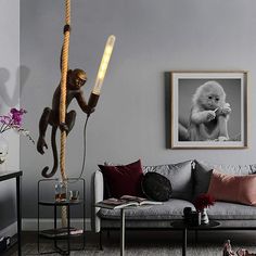 a living room filled with furniture and a monkey on top of the wall next to a lamp