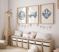 there are three pictures hanging on the wall in this child's room, and one has a giraffe