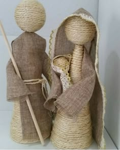 two burlap dolls are standing next to each other, one holding a stick