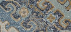 a blue and gold rug with an abstract design