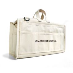 the atlantic rancher co canvas tote bag is white and has black lettering on it