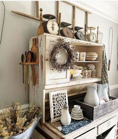 an old dresser is filled with dishes and utensils in this country style kitchen