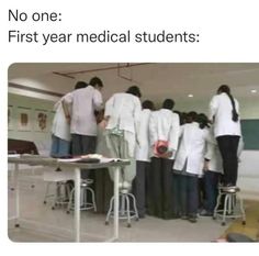 several people in lab coats standing around a table with papers on it and the caption reads, no one first year medical students