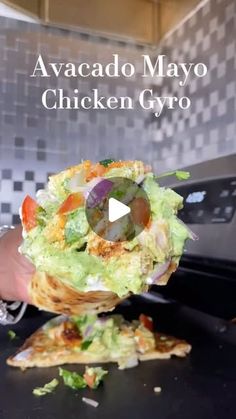 a person holding food in their hand with the words avacado mayo chicken gyro