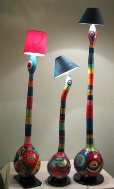 three colorful lamps sitting on top of a white table