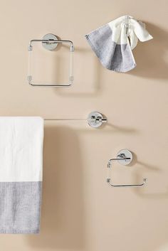 two towel racks with towels hanging on them and one holding a folded white cloth in front of it