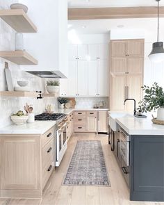 a kitchen with wooden cabinets and white counter tops, along with a rug on the floor