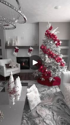 a living room with a christmas tree in the center and red decorations on the walls