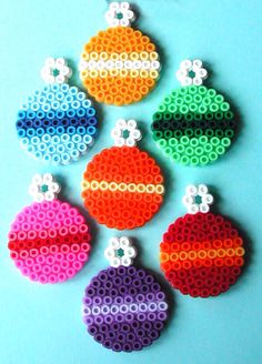 six different colored beads are arranged in the shape of baubles on a blue background