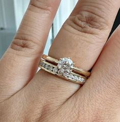 a woman's hand with two wedding rings on top of her finger and the other half