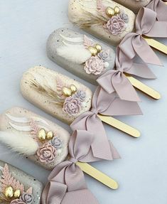 there are five pairs of hair clips with flowers and feathers on them, all decorated in pastel colors