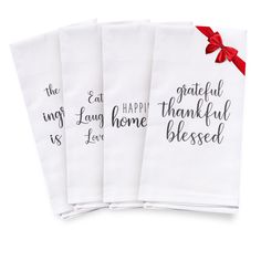 four white napkins with red ribbon tied around the edges saying, happy home is loved