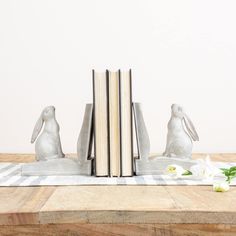 the bookends are made out of wood and have rabbits sitting on top of them