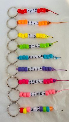 six personalized keychains with different colors and names are arranged in a row