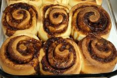 a pan filled with cinnamon rolls sitting on top of a counter