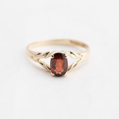 Hello. This is a pretty garnet ring in 10k yellow gold. It is marked 10k on the inside of the ring. The oval garnet is genuine and measures 7x5mm. The ring finger size is 7.5. Sorry, we don't resize rings. The weight of the ring with gemstone is 1.9 grams. Thanks for looking! Vintage Oval Garnet Birthstone Ring, Heirloom Garnet Oval Birthstone Ring, Classic 14k Gold Oval Cabochon Birthstone Ring, Classic Oval Cabochon Birthstone Ring, Classic Oval Birthstone Promise Ring, Gold Oval Garnet Birthstone Ring, Ring With Gemstone, Resize Ring, Garnet Ring