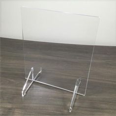 a clear acrylic sign holder on a wooden floor with a white wall in the background