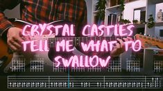 a man holding a guitar with the words crystal castles tell me what to shallow on it