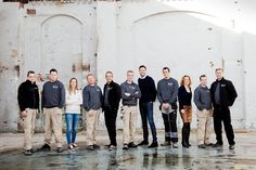 a group of people standing next to each other in front of a white brick building