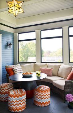 a living room filled with furniture and large windows