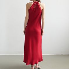 Introducing our exquisite Scarlet Halter Dress. Crafted from luxurious satin in a mesmerizing shade of deep red, this dress is a celebration of opulence and style. The halter neckline gracefully accentuates the shoulders, while the front neck flower, adorned with meticulously placed crystals, adds a touch of celestial brilliance.  Designed to make a statement at any special occasion, the Scarlet Elegance dress drapes elegantly, flattering the silhouette with its tailored fit. The flowing skirt a Scarlet Dress, Floral Corsage, Elegance Dress, Neck Flower, Artisan Fashion, Handloom Fabric, Dress Drape, Silky Dress, Flowing Skirt