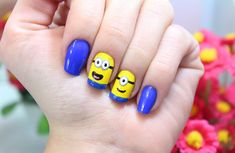 a person with blue and yellow nail polish on their fingers