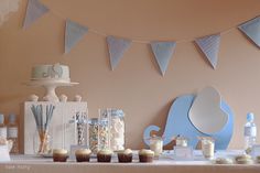 an elephant themed baby shower is set up on the table with cupcakes and cake