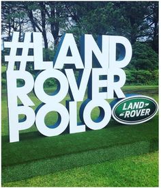 the land rover polo logo is displayed in front of some trees and green lawns