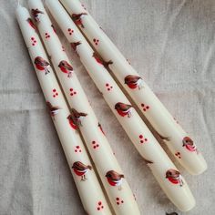 four white candles with red birds on them