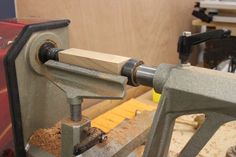 a machine that is sitting on top of a wooden table next to a piece of wood