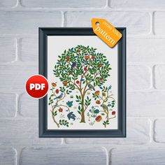 an image of a tree with birds and flowers on it in a frame next to a white brick wall