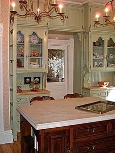 a kitchen with an island in the middle of it and lots of lights hanging from the ceiling