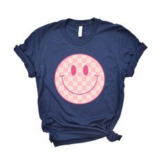 Looking for a cute versatile top to wear this summer? Make sure to grab one of our Pink Checker Smiley Face tees! This soft and comfortable graphic tee is the perfect top for any outfit. It can be paired with biker shorts, jeans, or even a simple skirt/dress! This tee is true-to-size, so be sure to order your regular t-shirt size! If you are looking for a more oversized look, make sure to size up! Smiley Face Tee, Simple Skirt, Shorts Jeans, Skirt Dress, Biker Shorts, Smiley Face, Smiley, Dress Skirt, Pink Ladies