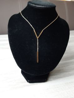 Beautiful gold necklace with V- shape pendant.  The necklace has a small link chain under the V shape with a stick  underneath as a pendant. The ting link chain is made of stainless steel. The chain has a lobster claw as a clasp. It is a link necklace and fits any type of clothing. Size chain: 15,75 inches + 1,97 inches long. The necklace has a chain of 1,18 inches under the V shape, and the stick is 0,98 inches long. The jewelry is sent in a box or in a organza bag. The jewelry will be packages in a bubble wrap that fits in the letterbox. Minimalist Y-shape Drop Necklace With Adjustable Chain, Minimalist Y-shape Adjustable Chain Necklace, Minimalist Y-shape Clavicle Chain Necklace, Gold Y-shape Adjustable Chain Necklace, Gold Y-shape Delicate Chain Necklace, Gold Y-shape Chain Necklace With Adjustable Chain, Gold Y-shape Necklace With Adjustable Chain, Minimalist Metal Drop Necklace With Adjustable Chain, Chain With Pendant