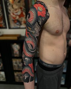 a man with a dragon and flower tattoo on his arm is posing for the camera