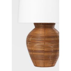 a lamp that is next to a basket on the wall with a white shade over it