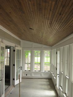 an empty room with white walls and wood ceilinging is shown in the foreground