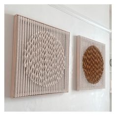 two wall hangings on the side of a white wall next to each other with woven circles