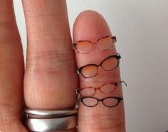 two fingers with glasses drawn on them, one has a ring and the other has a pair of eyeglasses