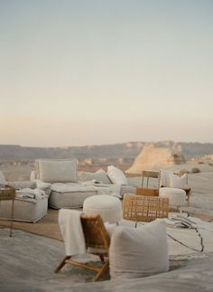 the couches and chairs are all covered with white linens in the desert setting