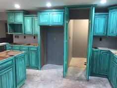 an unfinished kitchen with green cabinets and white counter tops