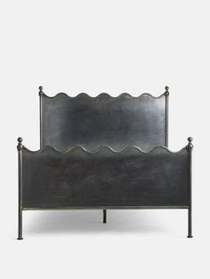 a metal bed frame with scalloped headboard