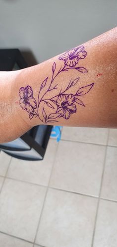 a person with a flower tattoo on their arm