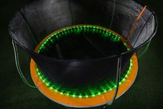 an orange and black trampoline with green lights